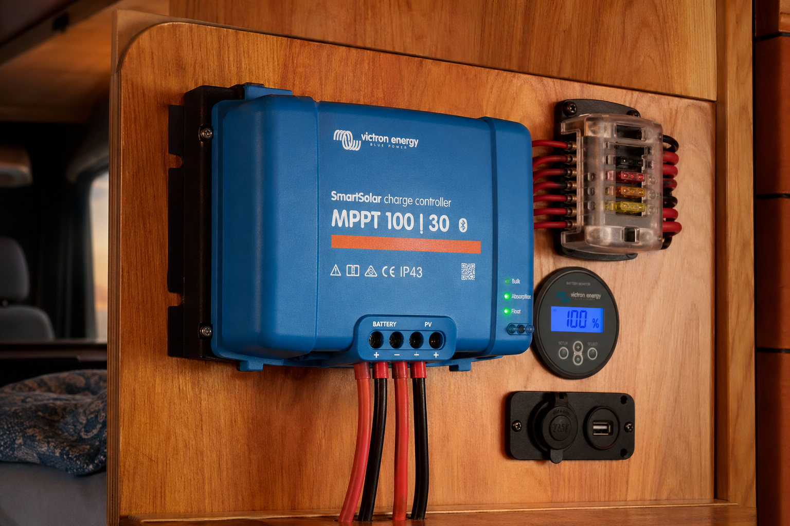 Victron MPPT solar charge controller mounted on a plywood electrical panel inside a van with status LEDs glowing